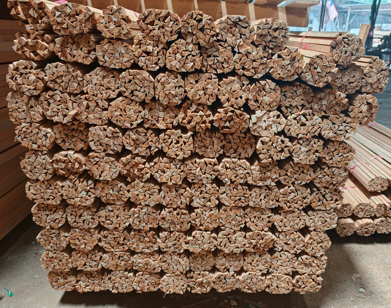 Bundled meranti beading stacked in rows, with the triangular profile ends clearly visible